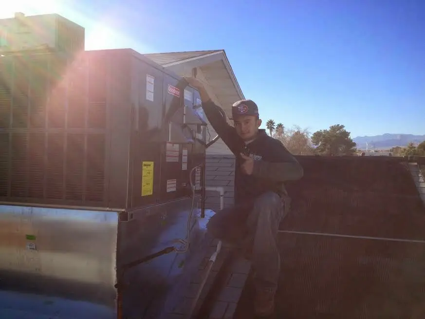 HVAC technician performing AC Tune-Up on a rooftop unit in Benbrook